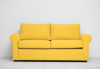 Yellow sofa on white wall background