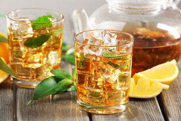 Two glasses of iced tea with lemon on a table