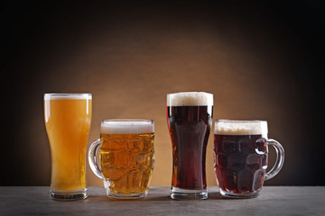 Different sorts of draft beer in glasses on wooden table
