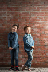 Two stylish little girls on wall background