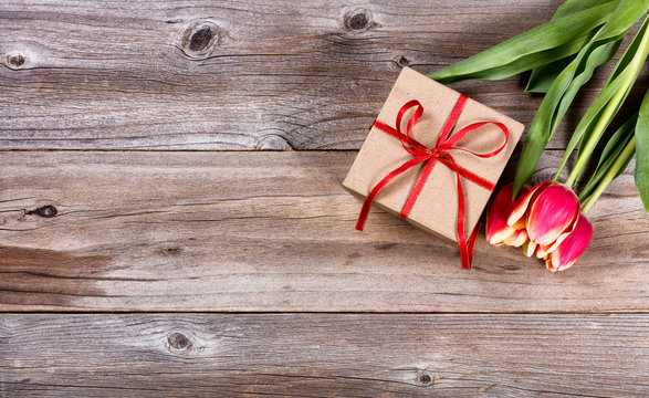 Present and flowers on stressed wood background