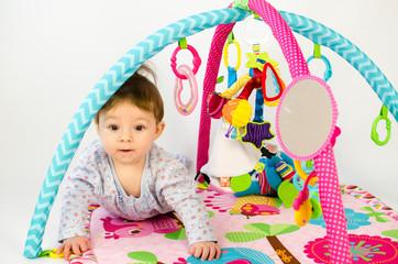 baby girl playing in an activity gym