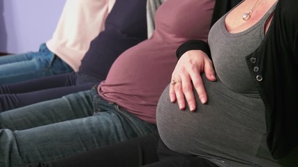 Pregnant women showing bellies and female hands touching them, group of moms with expectant tummies in line, mothers during pregnancy. Maternity, motherhood, new life and fertility - Powered by Adobe