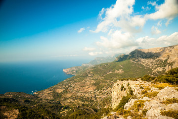Fototapeta na wymiar Beautiful landscape view of rocky mountains and clouds on the western part of Mallorca island, Spain. Tramuntana mountains with blue sea in background. Tourist trekking destination in Spain.
