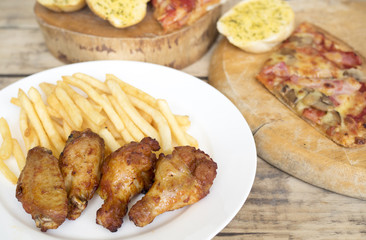 Fast food, crispy chicken wings,bread,french fries and pizza on