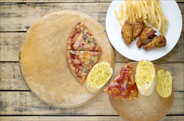 Fast food, crispy chicken wings,bread,french fries and pizza on