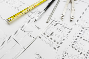 Measuring Tape, Pencil, Ruler and Compass Resting on House Plans