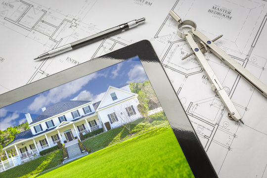 Computer Tablet Showing House Image On House Plans, Pencil and Compass