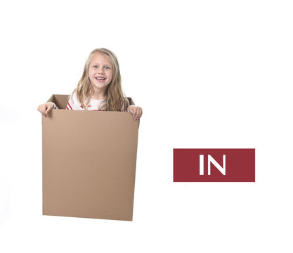 cute and sweet blond hair child in cardboard box isolated on white background in learning english prepositions