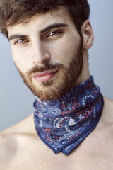 Close up of handsome man with long beard and blue scarf around his neck. © anderpe
