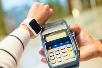 Woman using wearable smartwatch for paying on pos machine