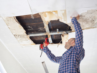 Man repairing collapsed ceiling - 107030894