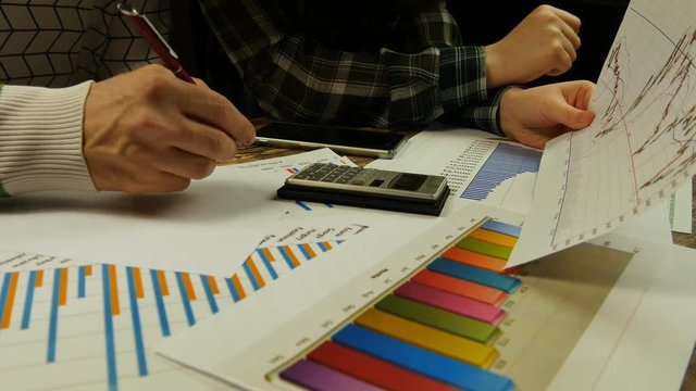 People discussing graph and study charts close-up