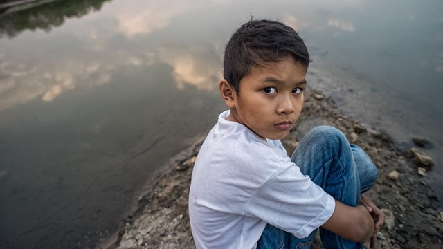 scared and alone, young Asian child who is at high risk of being bullied, trafficked and abused, selective focus