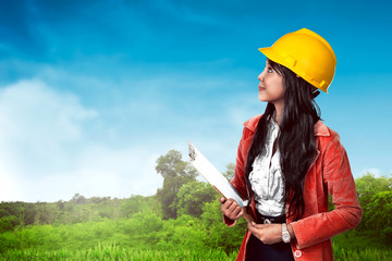 Woman wearing helmet holding clipboard