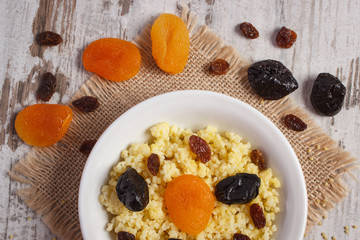 Cooked millet groats on white plate, healthy food and nutrition