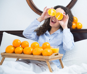 Obraz premium Young woman with orange juice and fruits