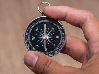 Close up of compass and point to North and hold by hand.