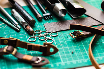Leather craft tools on green cutter board background