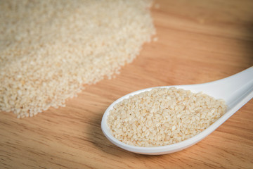 spoon of sesame in front of a blurry pile of sesame.Selective fo