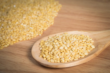 scoop of yellow beans seed in front of a blurry  pile of yellow