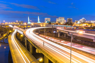 traffic on road with cityscape and skyline of portland at twilig