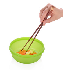 hand pick chopsticks eating in a green plastic bowl on white bac