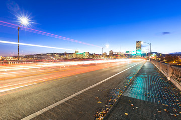 traffic on road with cityscape and skyline of portland at twilig