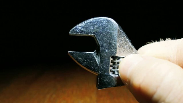 Brilliant adjustable spanner and male hands largely. 4K shot