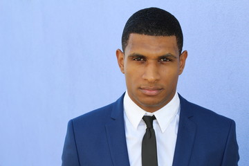 Dressing formally in blue suit, white shirt, tie, short haircut, confidently looking at you. Image with copy space for adding text