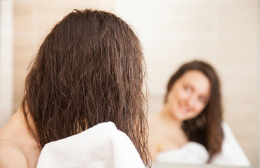 Young woman wiping hair after a shower