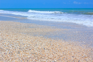 A tranquil sea scene and gravel beach. The sky above is a perfec