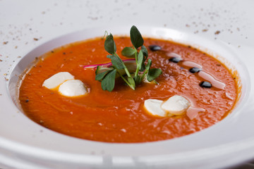 tomato soup, sour cream, radish, cucumber and herbs in the white plate