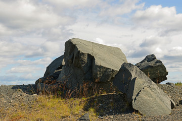 Huge stones of dead rock against northern country. Abandoned mine. Northern Finland