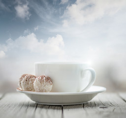 Cup with coffee on the sky background. Breakfast concept and idea