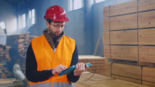 Warehouse worker uses a tablet. Writes data on the availability of building materials