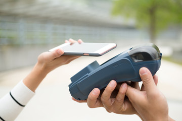 Woman pay with mobile phone on pos machine
