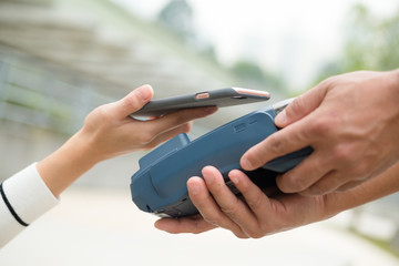 Woman pay on the pos machine with cellphone