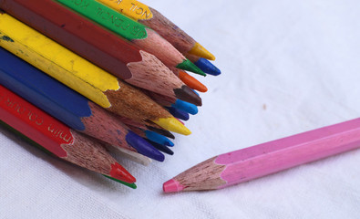 Fototapeta premium Team brainstorming, high angle view color pencils Colour Pencils with different one on white background, Business concept