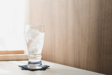 Glasses with ice cubes on wooden table