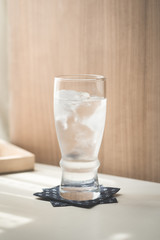 Glasses with ice cubes on wooden table