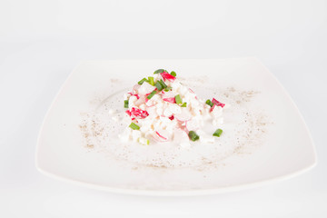 Cottage cheese with radish and chives on a white plate
