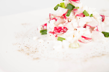 Obraz na płótnie Canvas Cottage cheese with radish and chives on a white plate