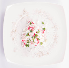 Cottage cheese with radish and chives on a white plate