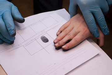 crime investigation. expert takes fingerprints of a suspect in a crime. - obrazy, fototapety, plakaty