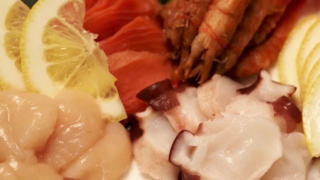 Finished dish of raw seafood and vegetables with lemon. Food Korean cuisine.