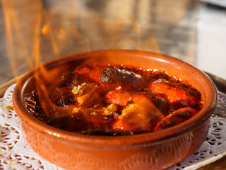 Brandy Flamed Chorizo sausages served as tapas in restaurant, Barcelona, Spain