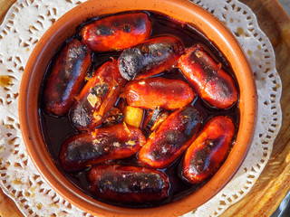 Brandy Flamed Chorizo sausages served as tapas in restaurant, Barcelona, Spain
