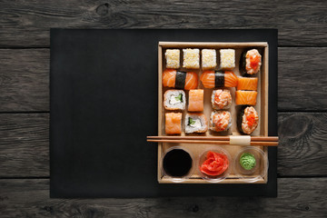 Set of sushi maki and rolls at black rustic wood.