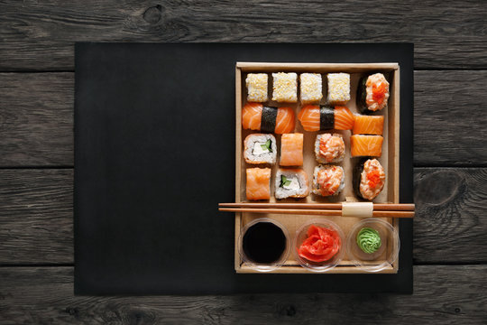 Set of sushi maki and rolls at black rustic wood.